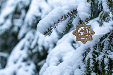 Wooden ornament on Christmas tree in the snow