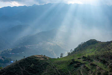 Sun rays illuminating the green rice terraces in the valley and the mountains of northern Vietnam at Sapa