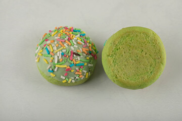 Two green sweet doughnuts on a white background