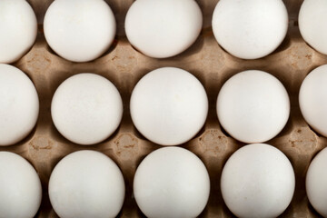Raw chicken eggs in egg box on a marble background