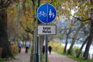 Allee am Fluss und Verkehrszeichen Getrennter Rad- und Gehweg mit Zusatzschild keine Mofas -...