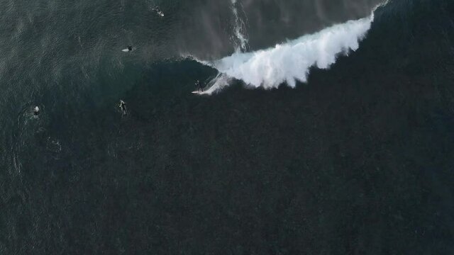 Surfer riding wave aerial top view