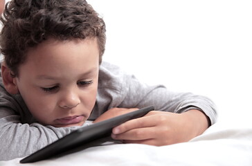 little boy looking at his mobile phone tablet on white background stock photo