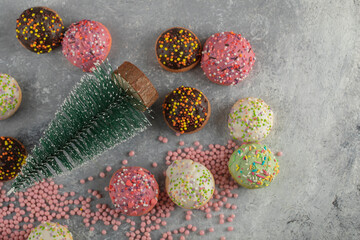 Colorful sweet small doughnuts with sprinkles and a cup of tea