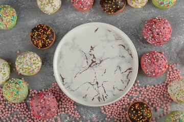 Colorful sweet small doughnuts with sprinkles and a cup of tea