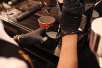 Fototapeta na wymiar Man steaming milk with espresso machine