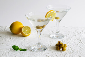 alcohol drinks. margarita cocktail in the bar. two martini glasses of cocktail with green mint and olives on white background. Glasses for martini with olives on the table. copy space.