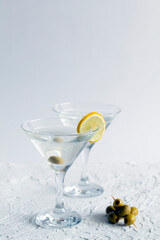 alcohol drinks. margarita cocktail in the bar. two martini glasses of cocktail and olives on white background. Glasses for martini with olives on the table. copy space. vertical
