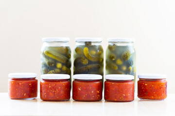 Fototapeta na wymiar glass jars with preserved tomatoes and cucumbers