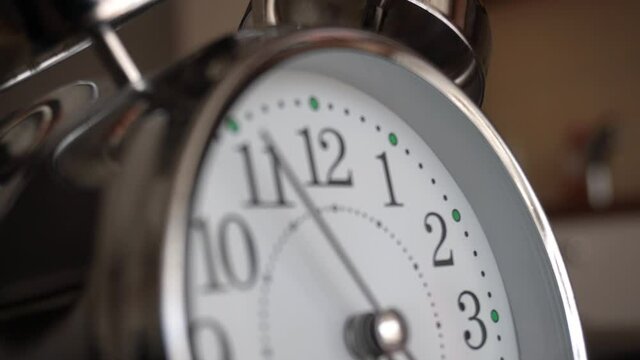 Big metallic clock close up. Time or showing time concept. Classic retro mechanical alarm clock with ringer. Time passing or waking up in the morning. 4k video