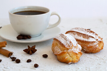 vanilla eclair on a plate on white background. Coffee cup with coffee beans and anise star, cinnamon sticks on white background. Traditional french tasty dessert. copy space
