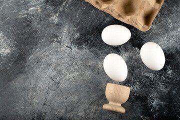 A wooden eggcup with boiled chicken eggs
