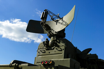 Air defense radar of military mobile mighty missile launcher system of green color, modern army industry, white cloud and blue sky on background
