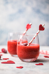 Fresh red strawberry margarita  or daiquiri cocktail with hearts over gray background, valentine day concepts