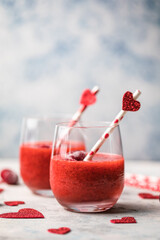 Fresh red strawberry margarita  or daiquiri cocktail with hearts over gray background, valentine day concepts