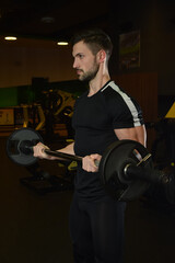 Fototapeta na wymiar Strong guy is training in the gym.