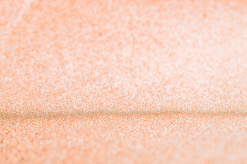 Pink gold. Christmas glitter golden background with bright sparkle bokeh texture for xmas shine silver pattern. Blurred vintage lights with copy space. Defocused.