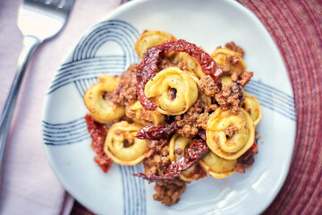 Tortellini with Bolognese Sauce and Sundried Tomatoes with Fork and Napkin, Closeup
