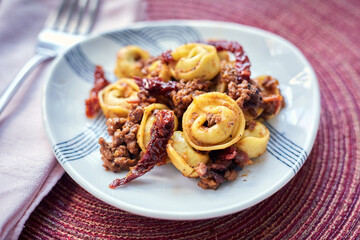 Tortellini with Bolognese Sauce and Sundried Tomatoes with Fork and Napkin, Closeup Side View