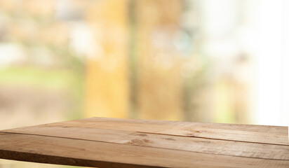 empty wooden table on blurred light gold bokeh of cafe restaurant on dark background, place for your products on the table