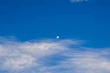 Fototapeta na wymiar Lua vista no dia, acima de nuvem, em céu azul