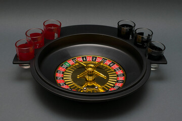 Drinking roulette on a gray background. Alcohol game for adults.