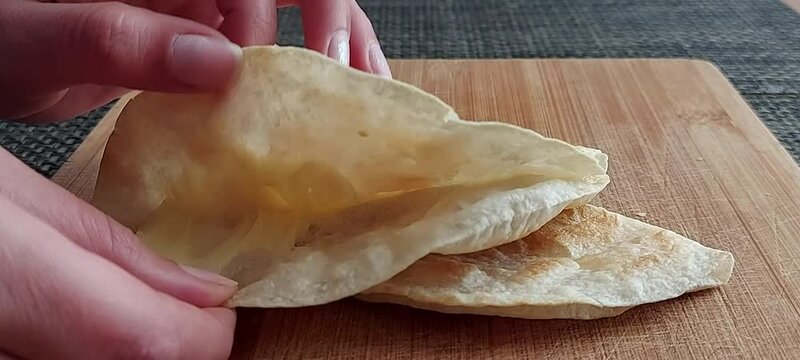 mujer abriendo quesadilla mexicana en tortilla de harina
