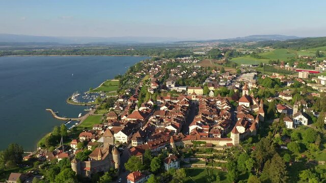Aerial drone footage of the famous Morat medieval old town by the Murten lake in Canton Fribourg in Switzerland. Shot with a backward and tilt down motion. 