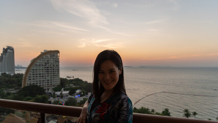 Fototapeta na wymiar An Asian woman portrait at the hotel with happiness and sunset time in the Pattaya beach, Thailand.