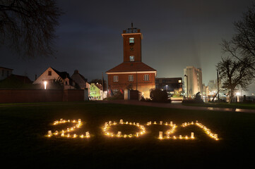 The year 2021 was represented with candles on the lawn in front of the historic telegraph building, in Brake Unterweser, Germany (the words "Breite Straße" in background are the name of this street)