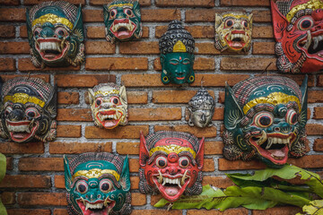 Balinese hindu masks on brick wall