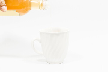 Honey bottle poured into glass isolated on white background