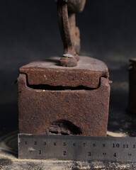 Old rusty antique iron for ironing clothes with the help of charcoal. Household antiques. Iron for clothes made of traditional steel with a wooden handle (Ayam Jago). Detailed photo of an old iron.