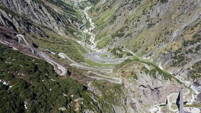 Aerial drone footage of the famous Gotthard pass mountain road near Andermatt in Canton Uri in Switzerland in the alps. Shot with a tilt down motion.