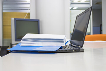 Blue Document folder with documents and Laptop on white table in meeting room