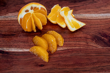 peeled and filleted orange on wooden board