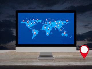 Map pin location button with connection line and world map on modern computer monitor screen on wooden table over sunset sky, Map pointer navigation online concept, Elements of this image furnished by