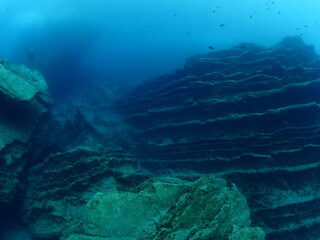scuba diver underwater with rocks discovering reefs ocean scenery human