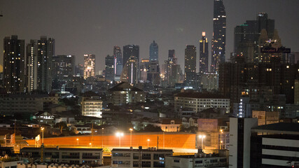 Obraz premium The high angle background of the city view with the secret light of the evening, blurring of night lights, showing the distribution of condominiums, dense homes in the capital community