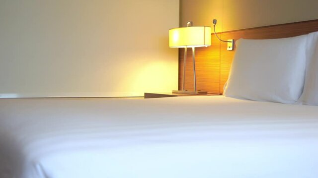 Pan from the foot of a well-appointed bed to pillows.