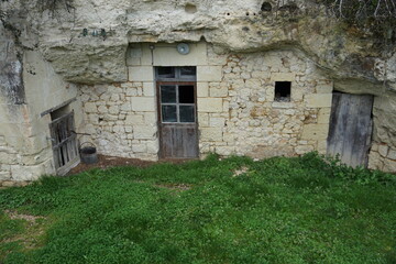 Fototapeta na wymiar old stone troglodyte with a broken wooden door in the Loire valley, France
