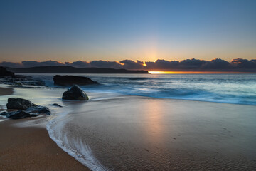 Sunrise by the sea with cloud bank on the horizon