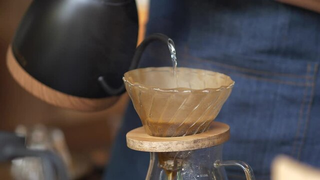 Hand drip worm water into coffee, Barista making drip coffee.
