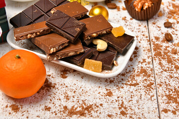 sweet food top view background for merry christmas or new year holiday decoration - chocolate candies, tangerines, cookies on white wood