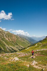 Fototapeta na wymiar Un randonneur dans la montagne. Un touriste dans les Alpes. Une randonnée en solitaire à la montagne.