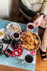 A lot of tasty Christmas gingerbread biscuits of a different shape and two cups of tea, a couple enjoying time together