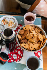A lot of tasty Christmas gingerbread biscuits of a different shape and two cups of tea, a couple enjoying time together