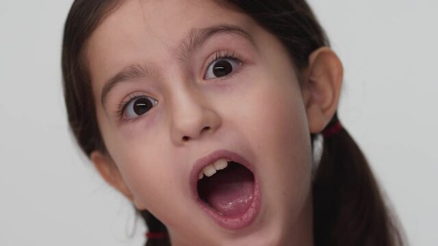 The girl looks up and is surprised and happy to have a surprise. Portrait beautiful little girl looking at camera.Close-up little girl.