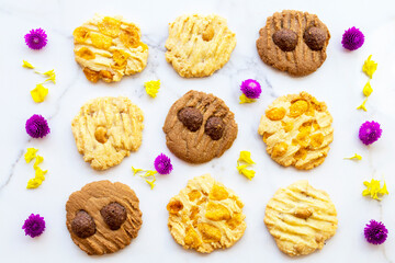 dessert snack cookies with flowers arrangement flat lay style on background white