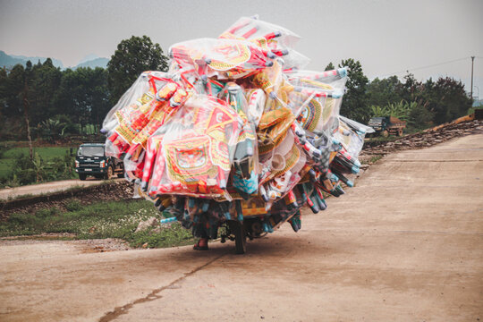 Vietnamese motorbike overloaded with cargo, shows the local culture and daily life in the countrysides of Vietnam
